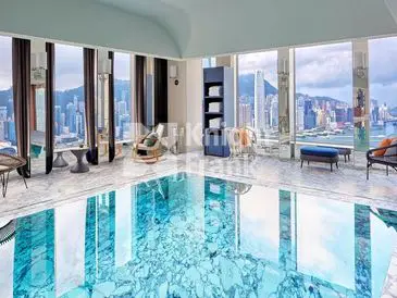 Luxurious indoor pool with city and mountain views through large windows.