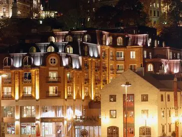 Warmly lit buildings at night in a European cityscape.