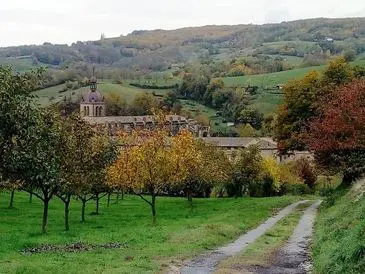 Scenic countryside with orchard and historic church.