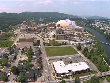 A large industrial complex with multiple buildings and surrounding greenery.