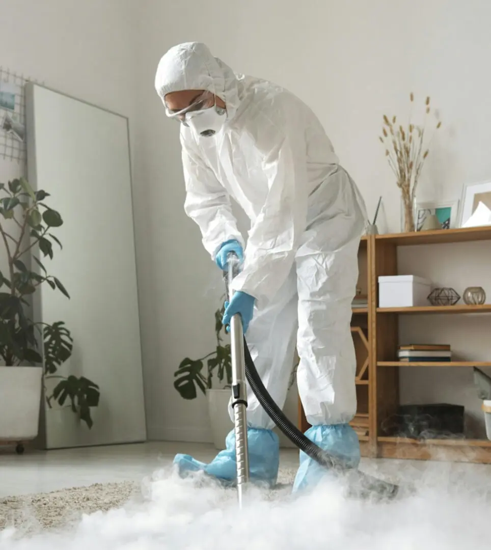 Person in protective suit disinfecting a room with fog.
