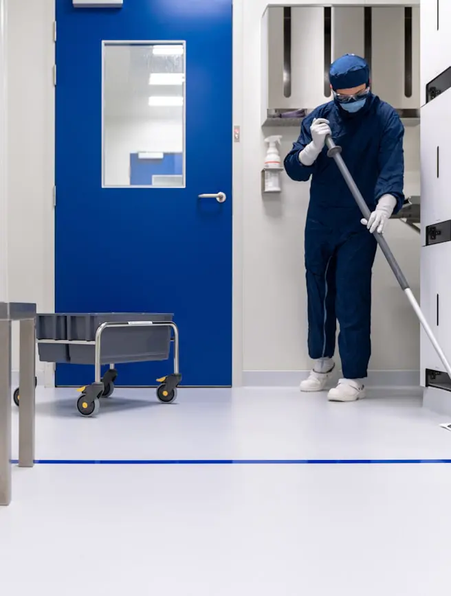 A janitor mopping a clean, modern hospital floor.