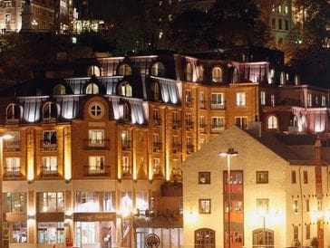 Warmly lit buildings at night in a European cityscape.