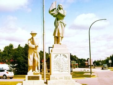 Statues of historical figures in a memorial park under a clear sky.