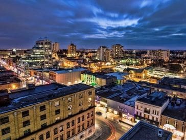 Cityscape at dusk with illuminated buildings and streets.