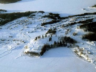 Snow-covered landscape with scattered trees and rolling hills.