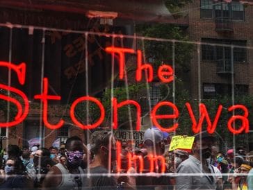 Reflection of a street scene on a window with 'The tonew inn' in red lettering.