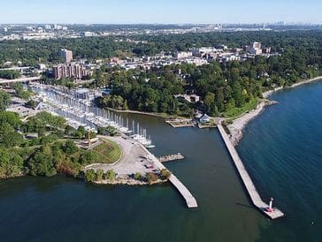Aerial view of a coastal city with docks and green spaces.