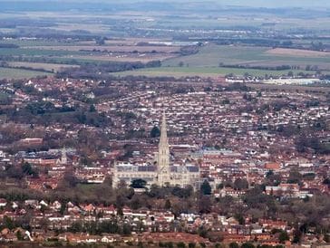 A town with a prominent church tower surrounded by fields.