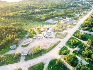 Aerial view of a small settlement surrounded by greenery and roads.