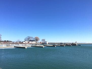 Boats docked at a marina under a clear blue sky.