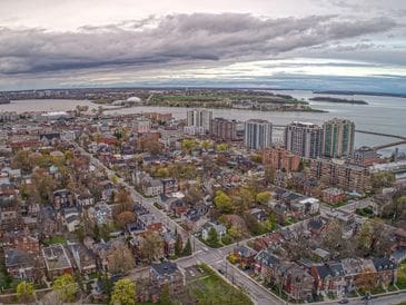 Aerial view of an urban area with residential and commercial buildings under a cloudy sky.