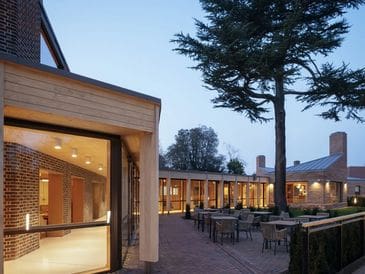 Modern building with outdoor seating under evening light.