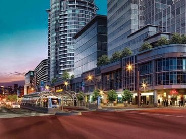 City street at dusk with modern buildings and streetlights.
