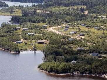 Aerial view of a lakeside village surrounded by forest.