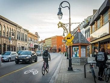 Cyclist rides on a designated bike lane in a charming urban street.