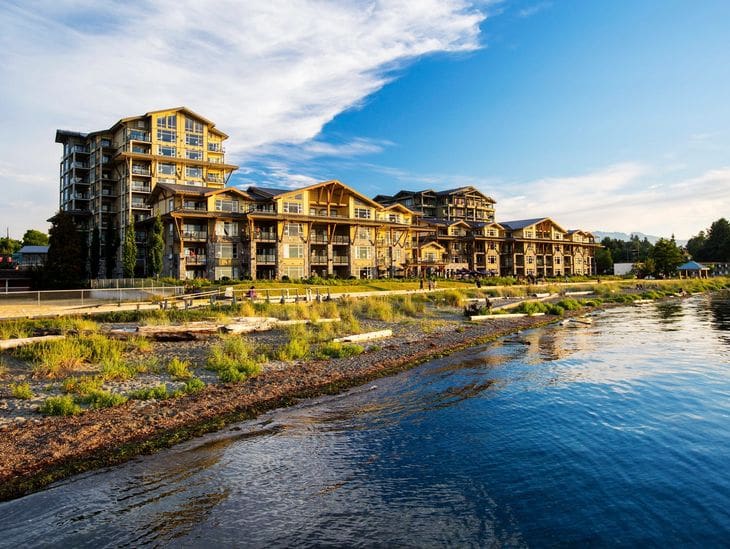 Lakeside resort with modern buildings under a blue sky.