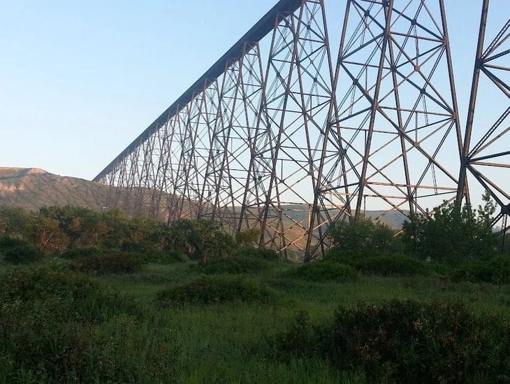 Tall metal bridge structure over green landscape.