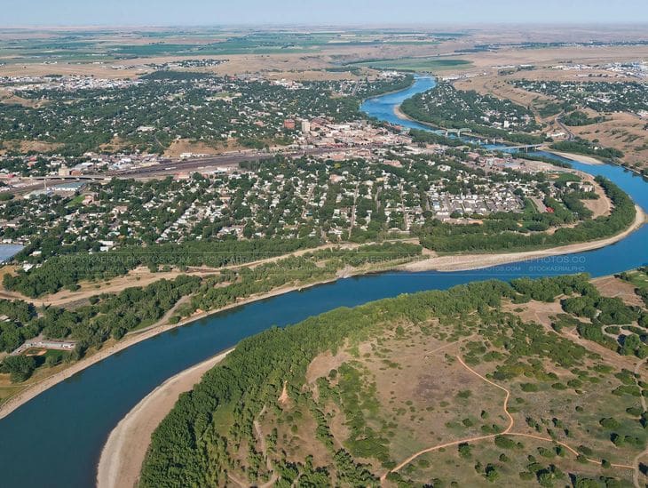 Aerial view of a winding river through a green landscape with scattered settlements.