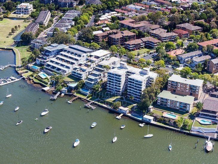 Aerial view of waterfront buildings with boats docked along the shore.