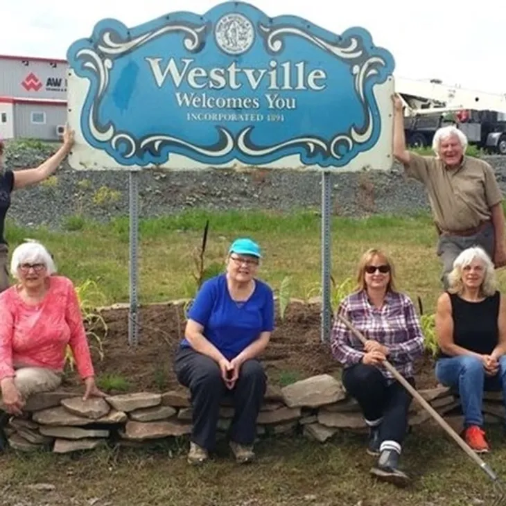 Group posing by Westville welcome sign