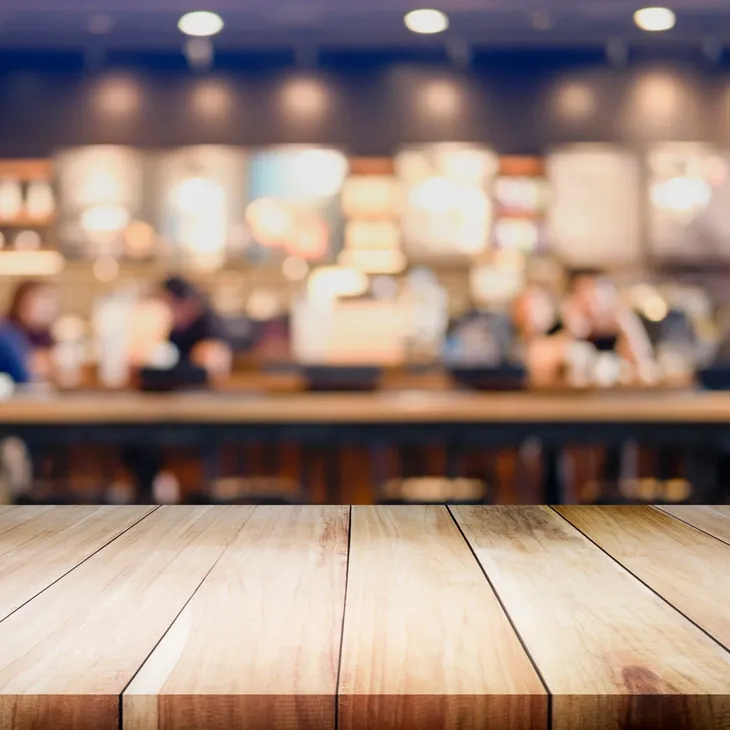 Wooden tabletop with blurred coffee shop background
